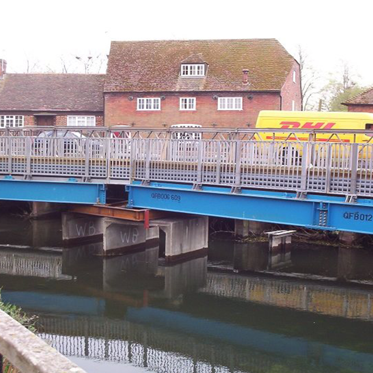 Mabey Hire pedestrian beam bridge on site over river by residential area